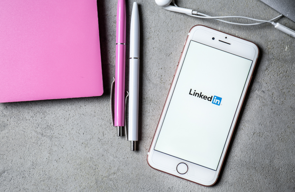How To Create Your First LinkedIn Ad title photo: smartphone on table displaying LinkedIn app logo